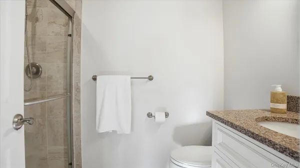 a bathroom with a granite countertop sink toilet and shower
