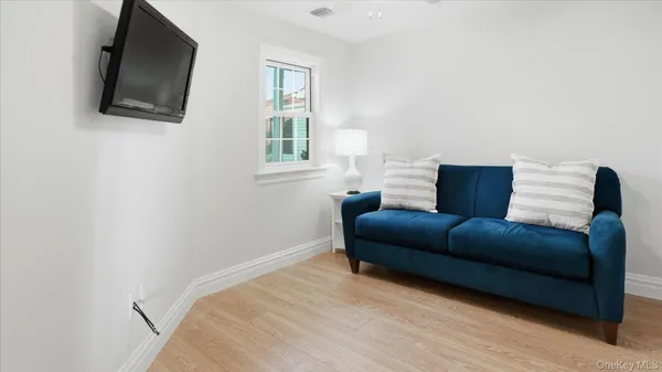 a bedroom with a bed a flat screen tv and windows