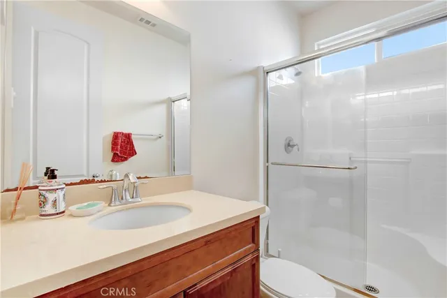 a bathroom with a sink toilet vanity and shower