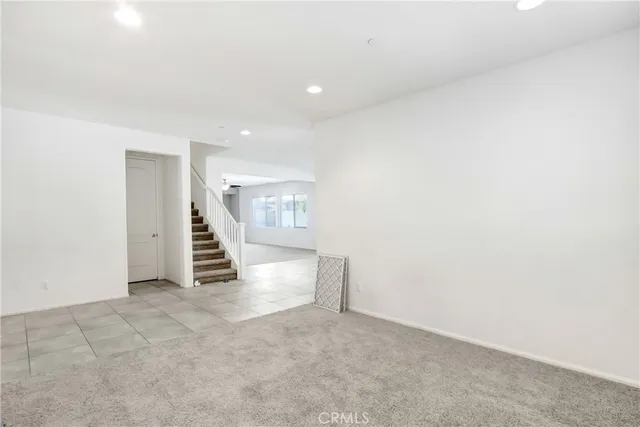 an empty room with a kitchen and a window