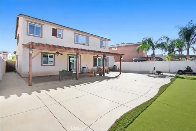 a view of a house with backyard and sitting area