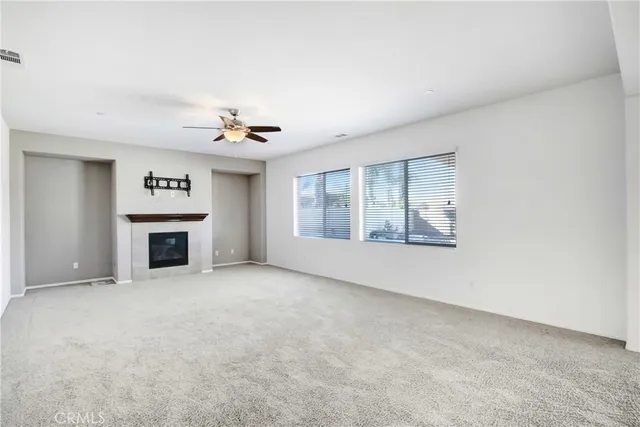an empty room with a fireplace and window