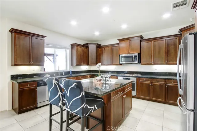 a kitchen with kitchen island granite countertop wooden cabinets and a stove top oven