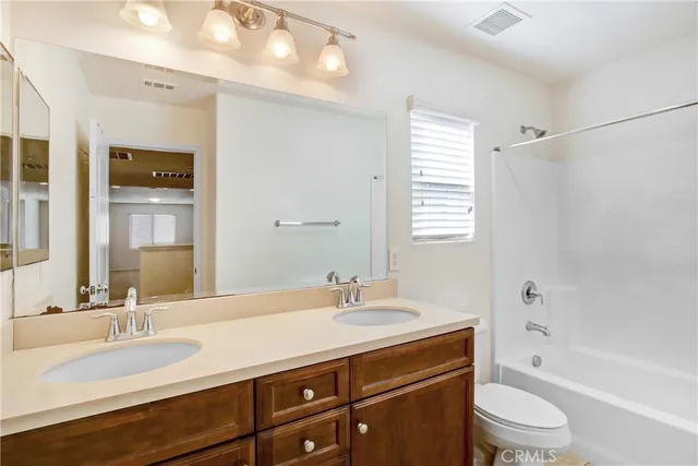 a bathroom with a granite countertop sink toilet a large mirror a shower and a bathtub