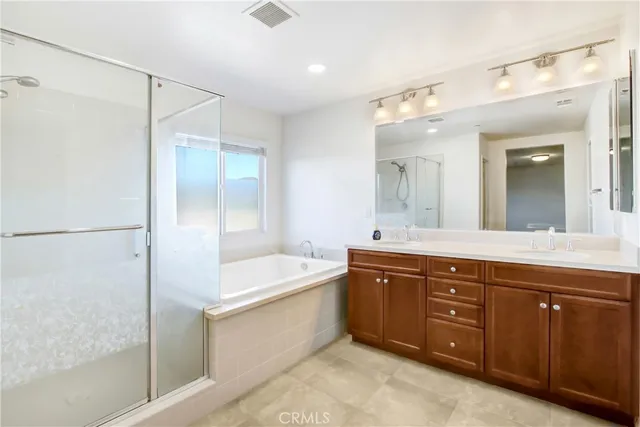 a spacious bathroom with a tub sink and mirror