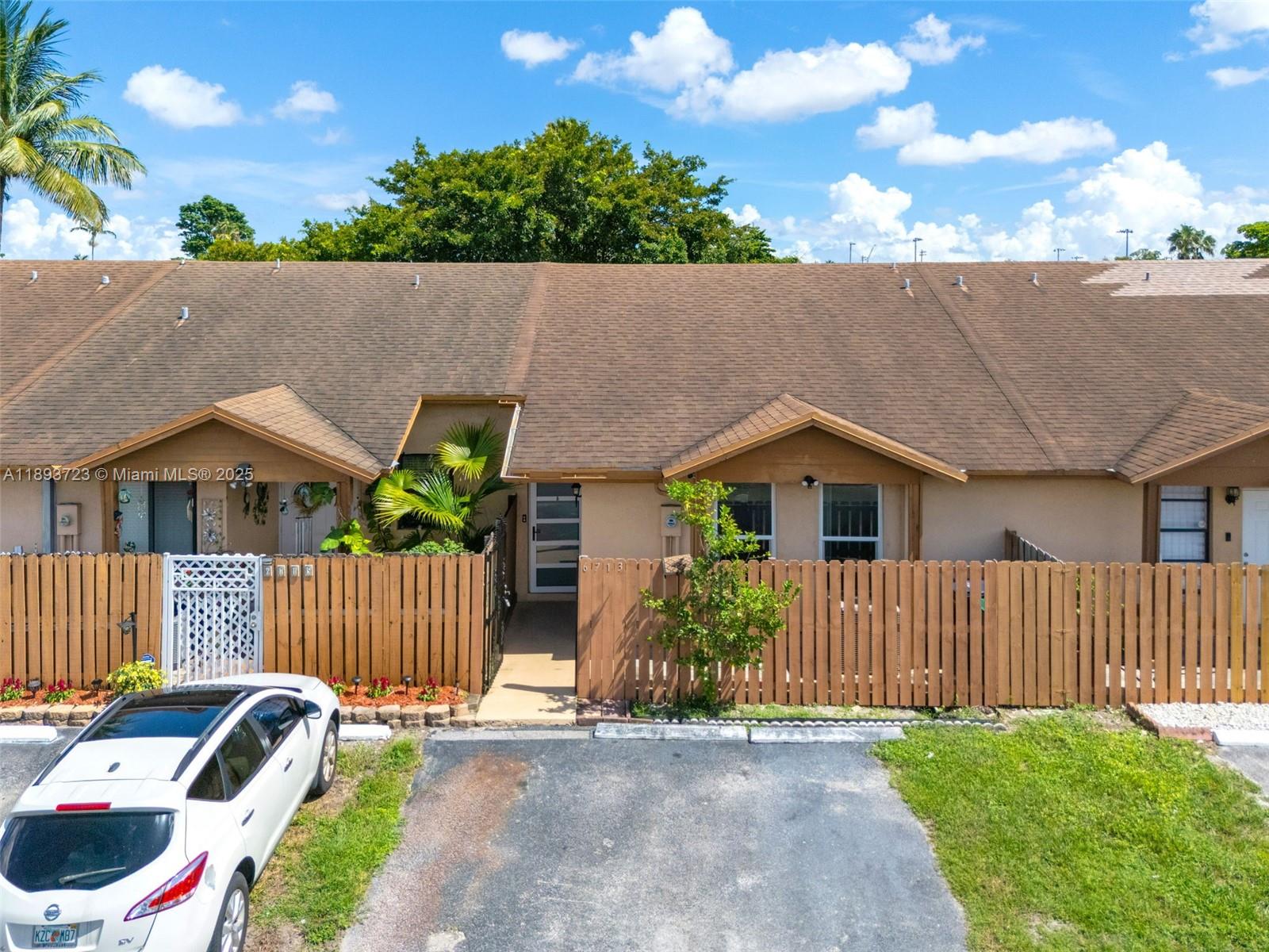 6713 Northwest 188th Terrace, Unit 6713 Hialeah, FL 33015 - Photo 1 of 28 a front view of a house with garden