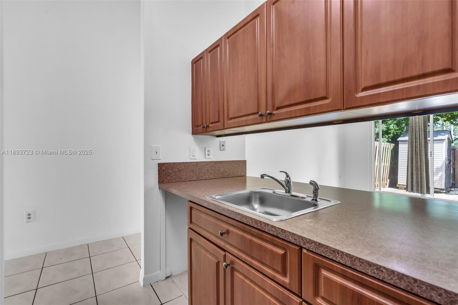 6713 Northwest 188th Terrace, Unit 6713 Hialeah, FL 33015 - Photo 4 of 28 a kitchen with granite countertop a sink and cabinets
