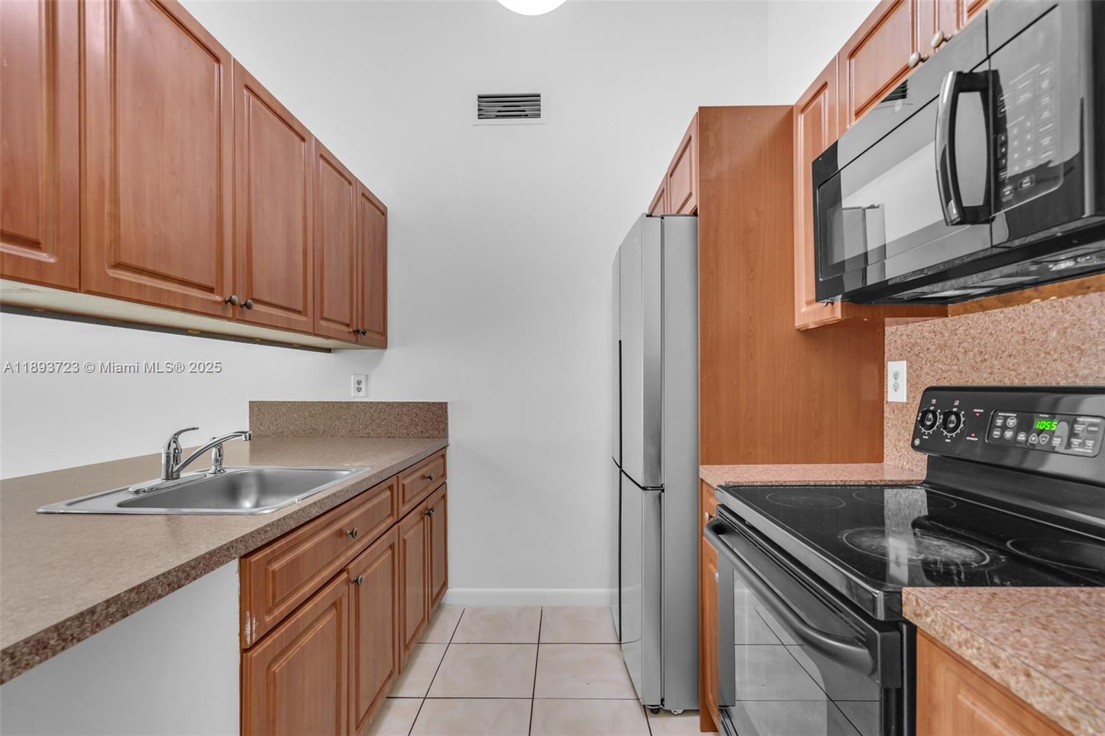 6713 Northwest 188th Terrace, Unit 6713 Hialeah, FL 33015 - Photo 5 of 28 a kitchen with stainless steel appliances granite countertop a sink stove and cabinets