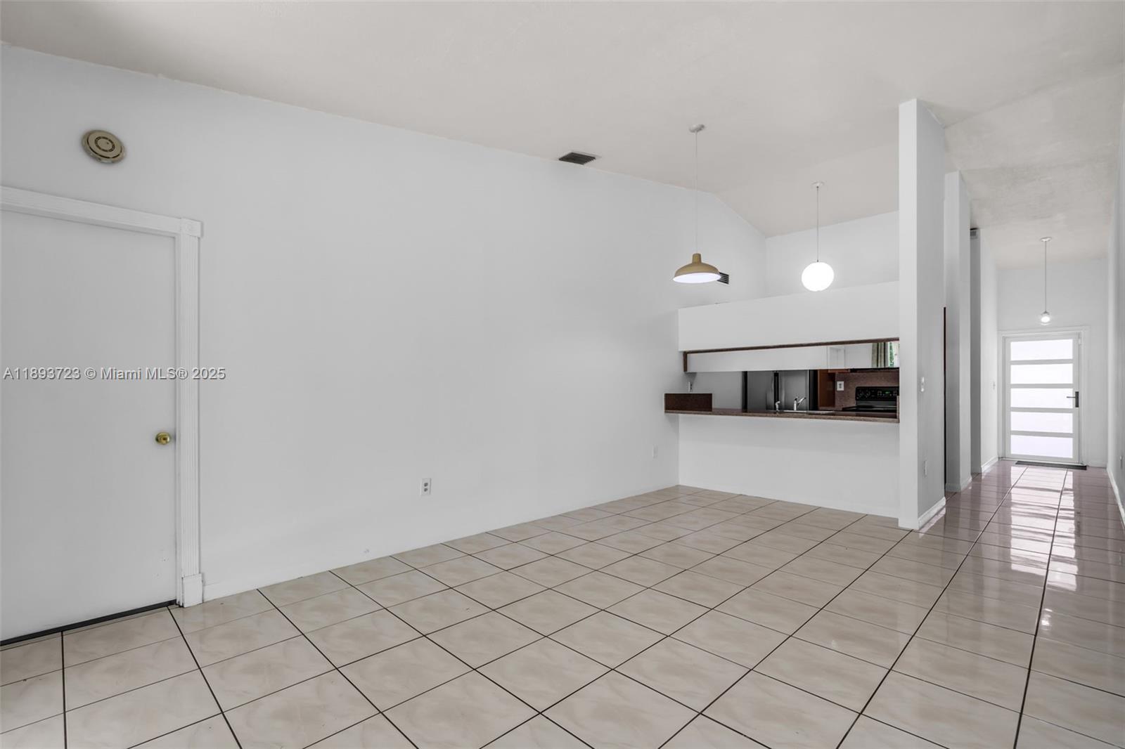 6713 Northwest 188th Terrace, Unit 6713 Hialeah, FL 33015 - Photo 7 of 28 a view of an empty room and kitchen view