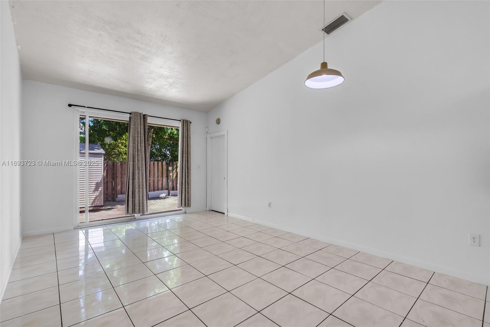 6713 Northwest 188th Terrace, Unit 6713 Hialeah, FL 33015 - Photo 8 of 28 an empty room with windows and outdoor view