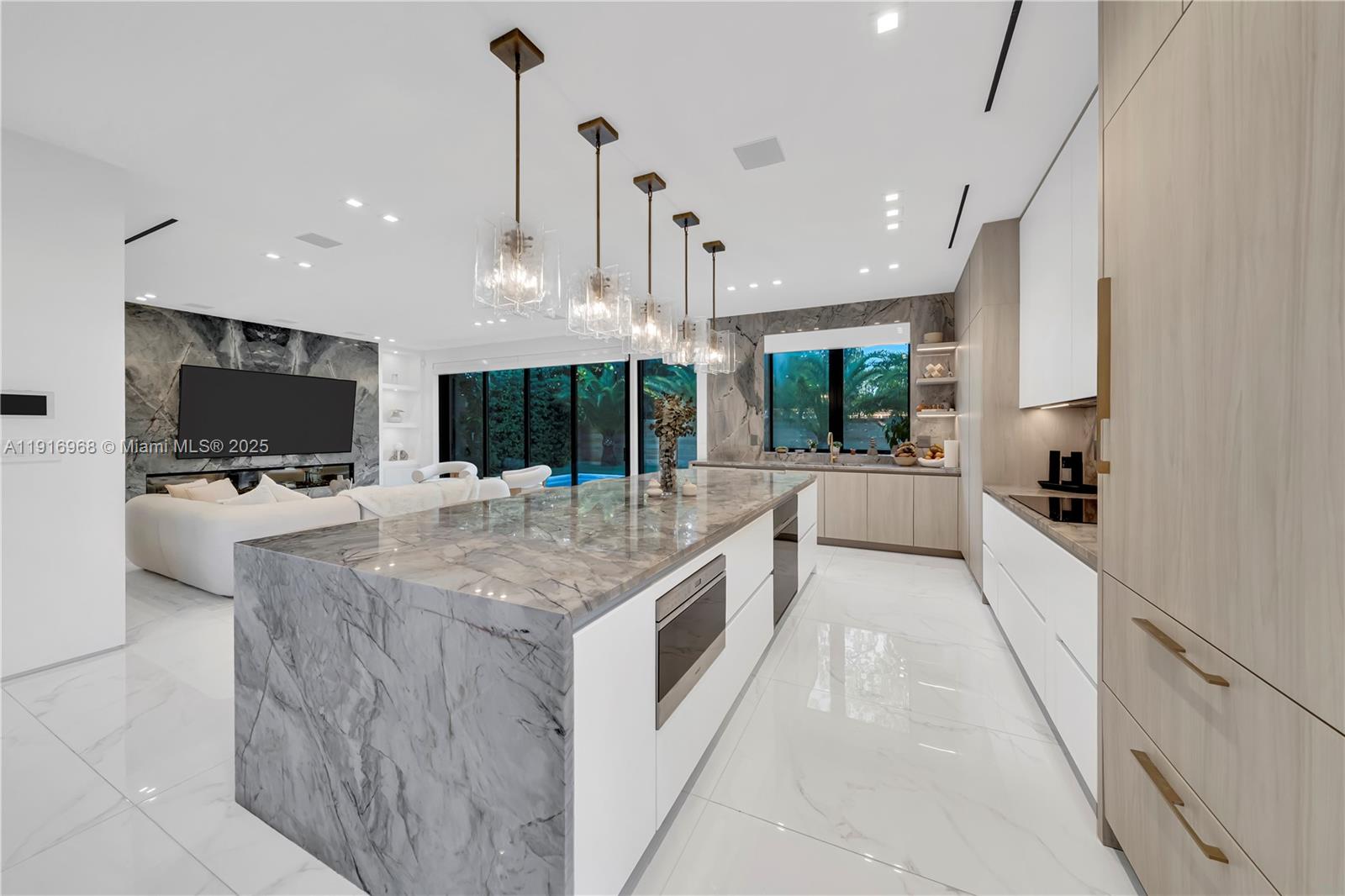 a kitchen with stainless steel appliances kitchen island granite countertop a stove and a flat screen tv