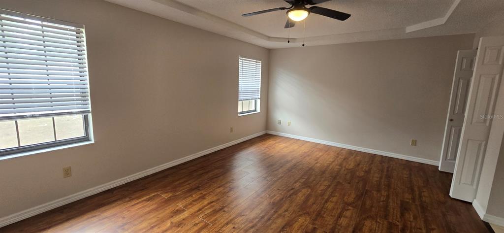 2710 Southwest 152nd Lane Ocala, FL 34473 - Photo 14 of 19 an empty room with wooden floor fan and windows
