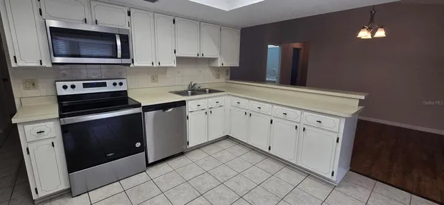 a kitchen with granite countertop white cabinets and black appliances