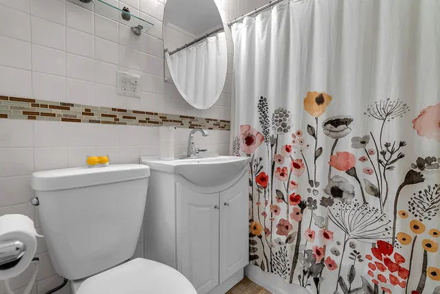 a bathroom with a sink and mirror with toilet