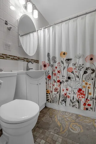 a bathroom with a toilet sink and mirror