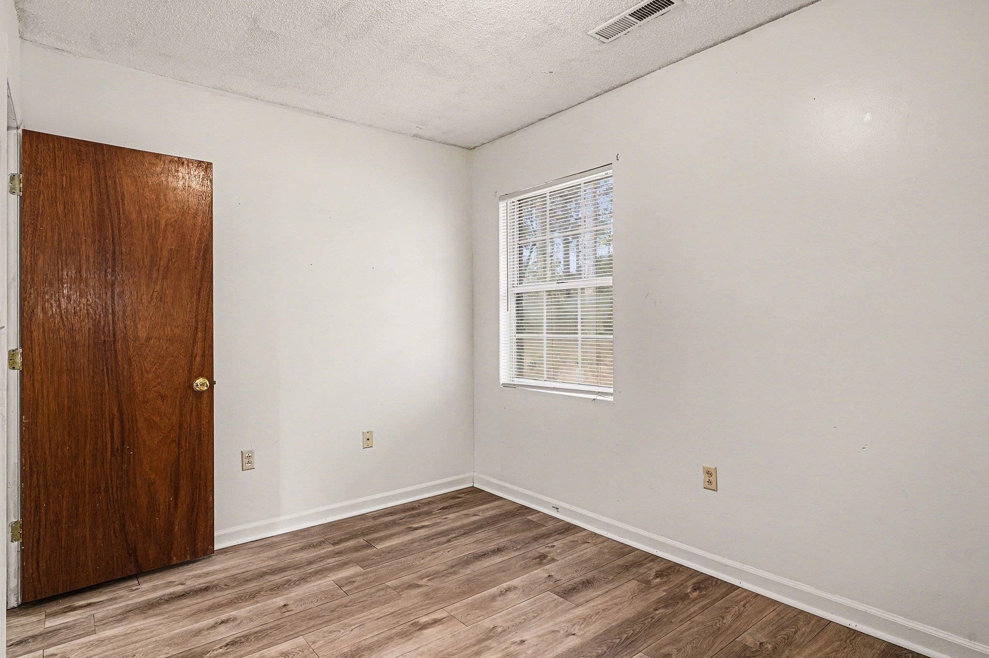 916 Brinkley Street Georgetown, SC 29440 - Photo 25 of 39 Unfurnished room featuring wood finished floors and a textured ceiling