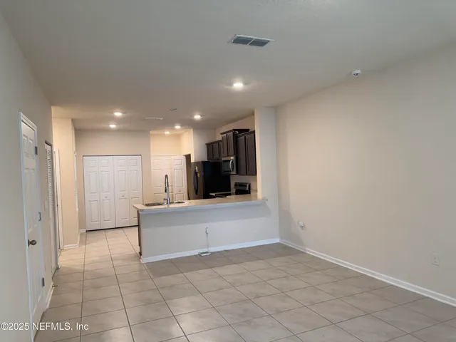 a view of kitchen with refrigerator and microwave