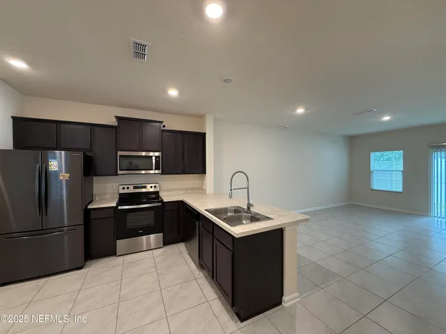 a kitchen with stainless steel appliances granite countertop a sink stove and refrigerator
