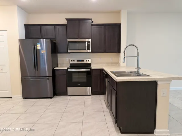 a kitchen with stainless steel appliances granite countertop a refrigerator and a sink