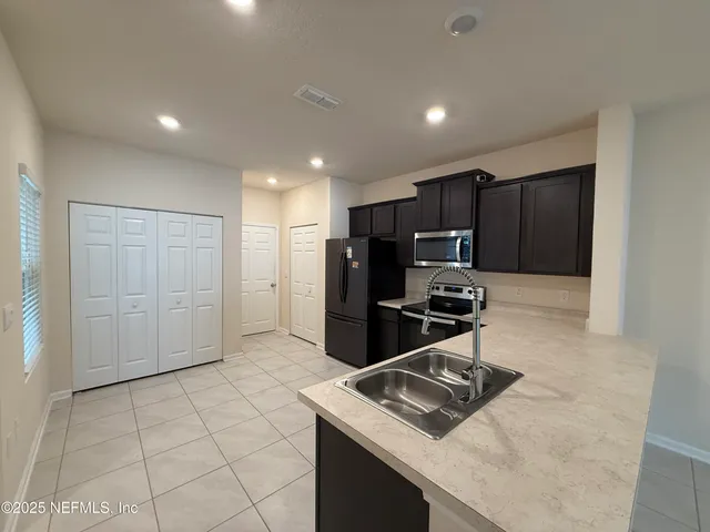a kitchen with stainless steel appliances granite countertop a refrigerator and a stove top oven