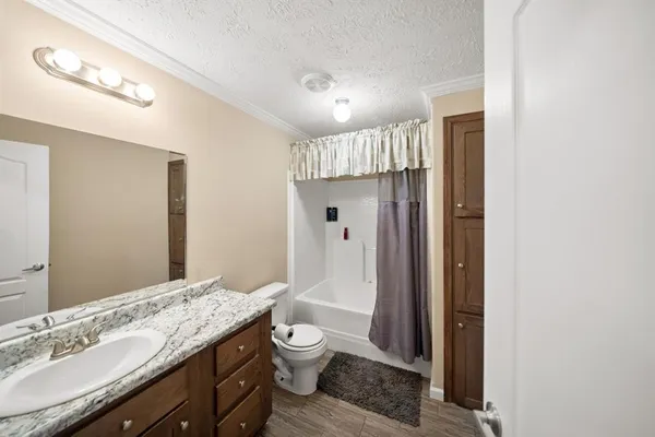 a bathroom with a granite countertop sink toilet and shower