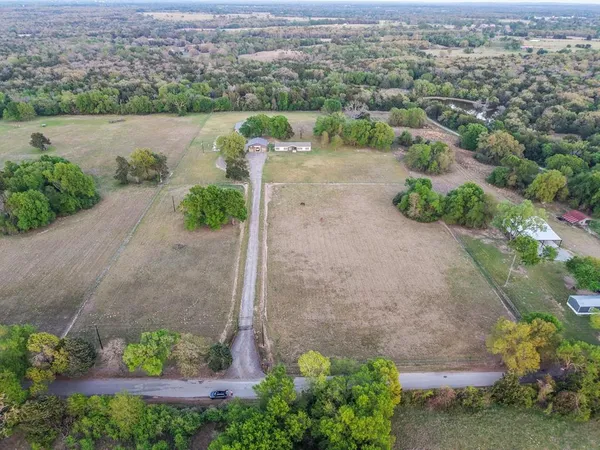 an aerial view of a house with a yard and lake view in back