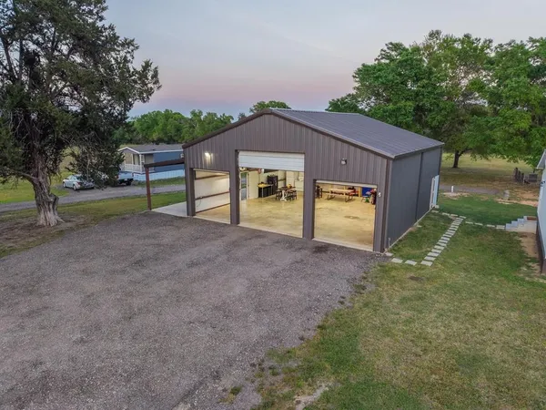 a view of a house with backyard and a tree