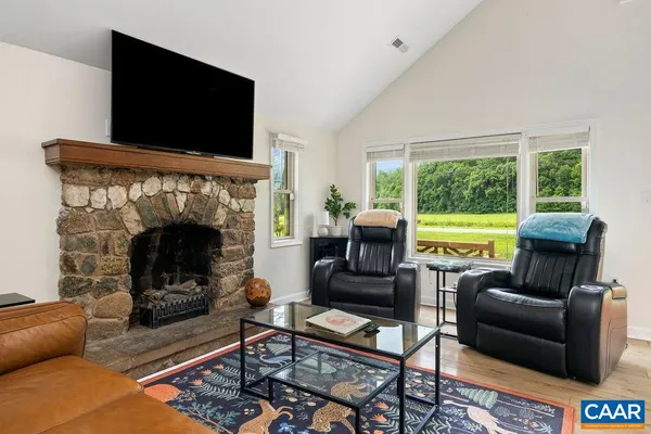 a living room with furniture fireplace and a large window