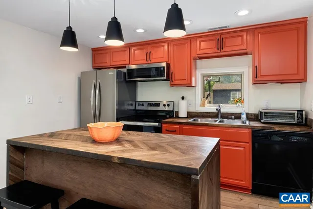 a kitchen with sink a microwave and cabinets
