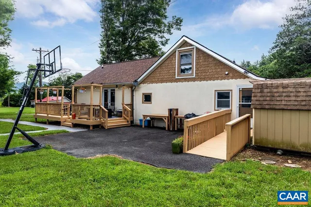 a view of a swimming pool and lounge chairs in back yard of the house