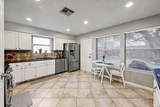 a kitchen with cabinets and chairs