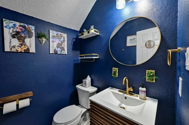 a bathroom with a toilet a sink and mirror