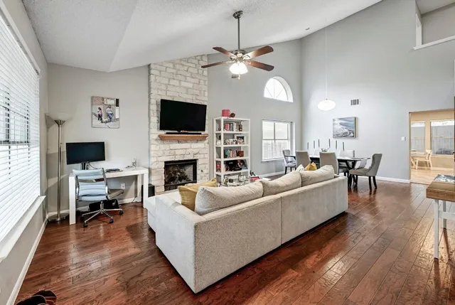 a living room with furniture a flat screen tv and a fireplace