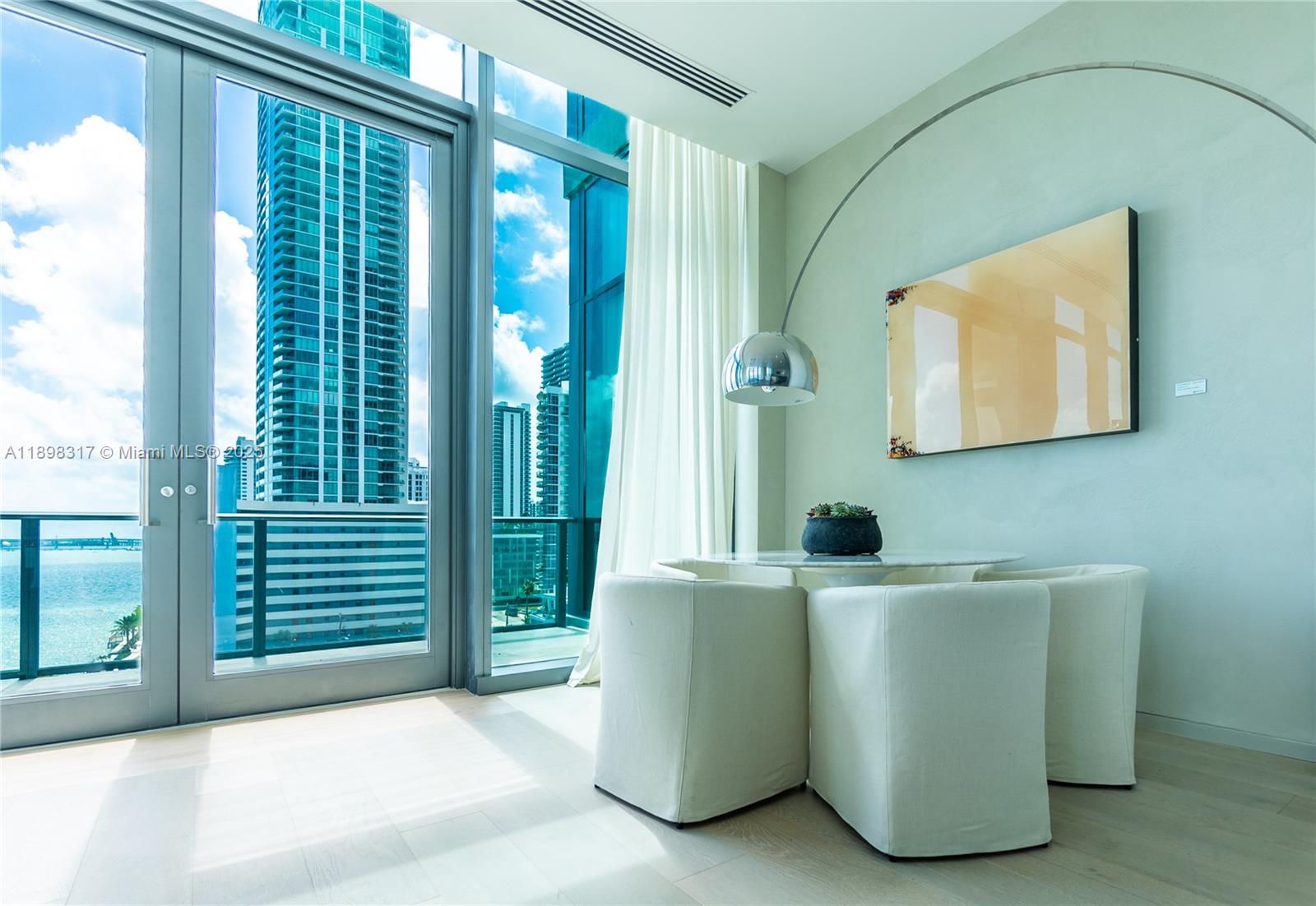 3131 Northeast 7th Avenue, Unit PH4903 Miami, FL 33137 - Photo 30 of 33 a living room with a couch and a chandelier