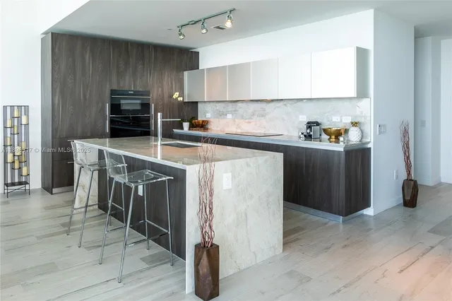 a kitchen with kitchen island a stove a sink a microwave and a refrigerator