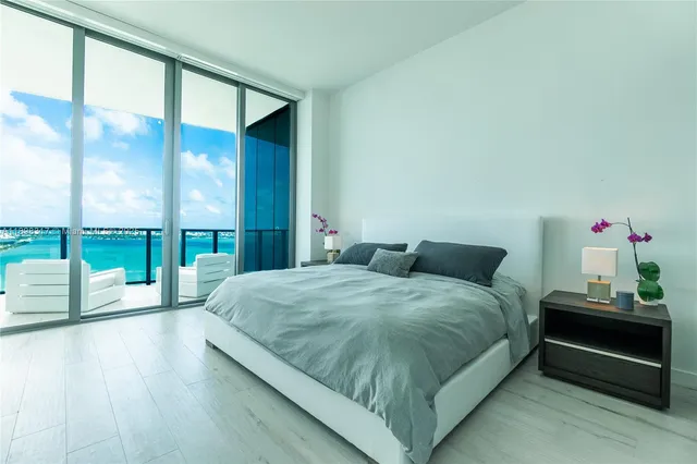 a bedroom with a bed and a large window