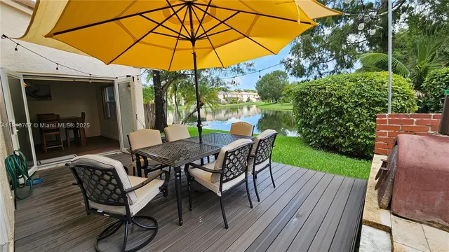 a view of a roof deck with table and chairs under an umbrella