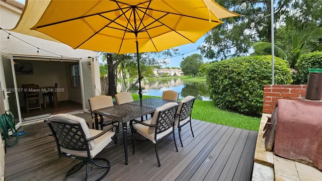 a view of a roof deck with table and chairs under an umbrella