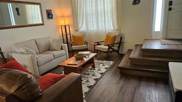 a living room with furniture a rug and a window