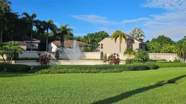 a view of a street in front of a house with a garden