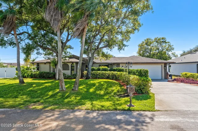 a front view of a house with a yard and potted plants