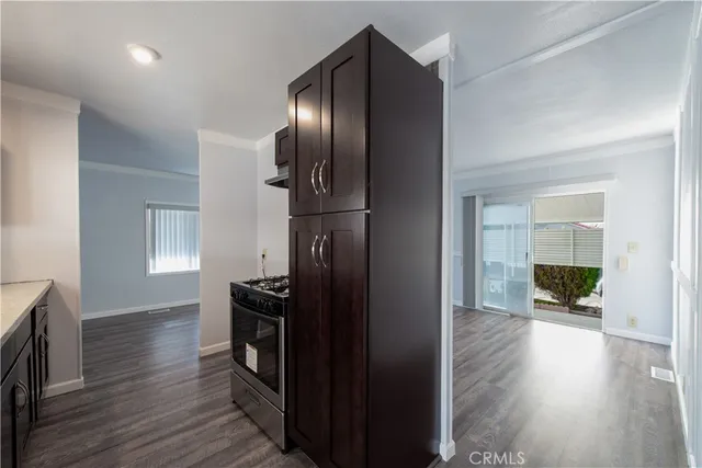 a kitchen with a refrigerator and wooden floor