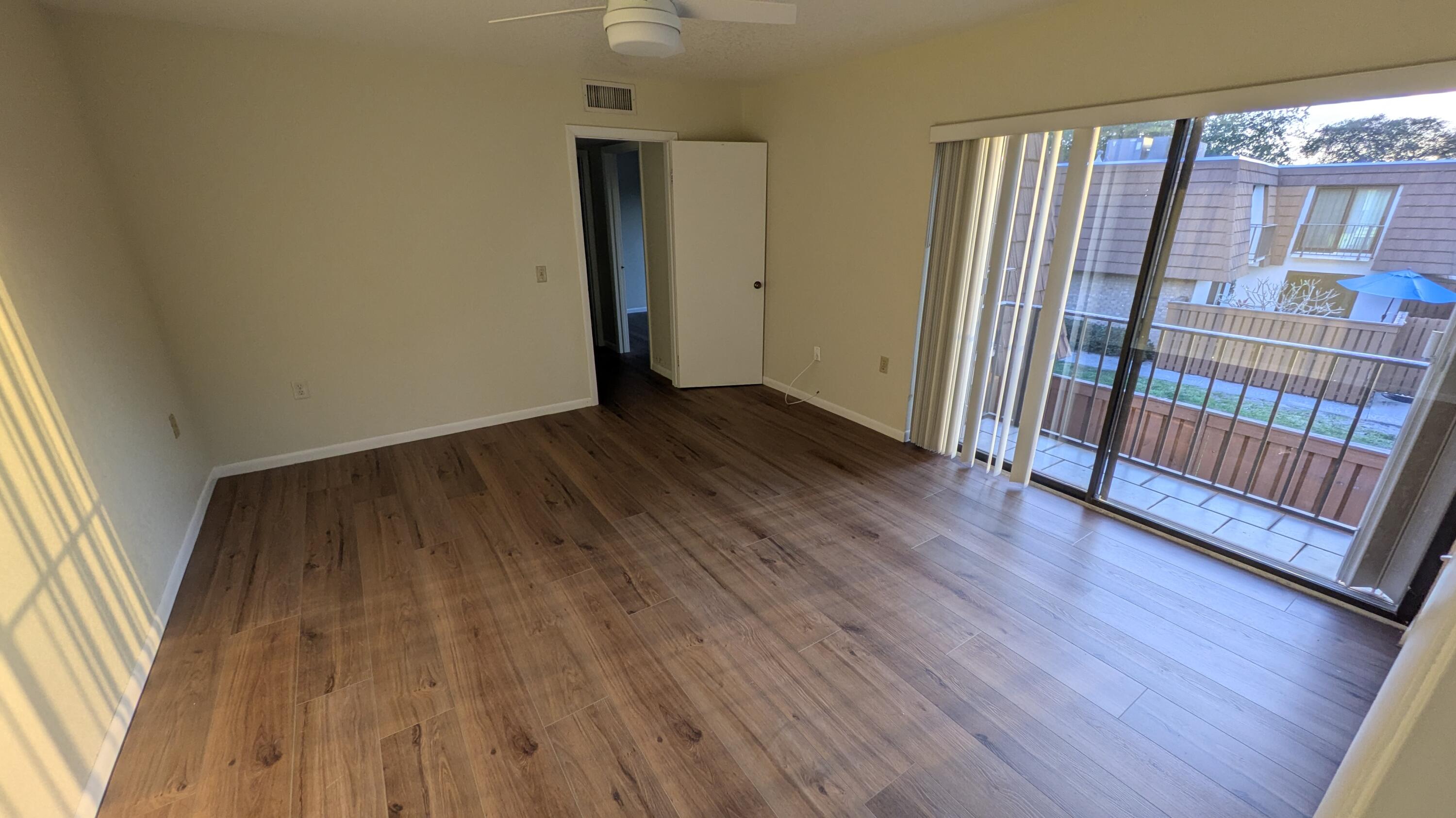 3900 County Line Road, Unit 21D Tequesta, FL 33469 - Photo 14 of 20 a view of an empty room with wooden floor and a window