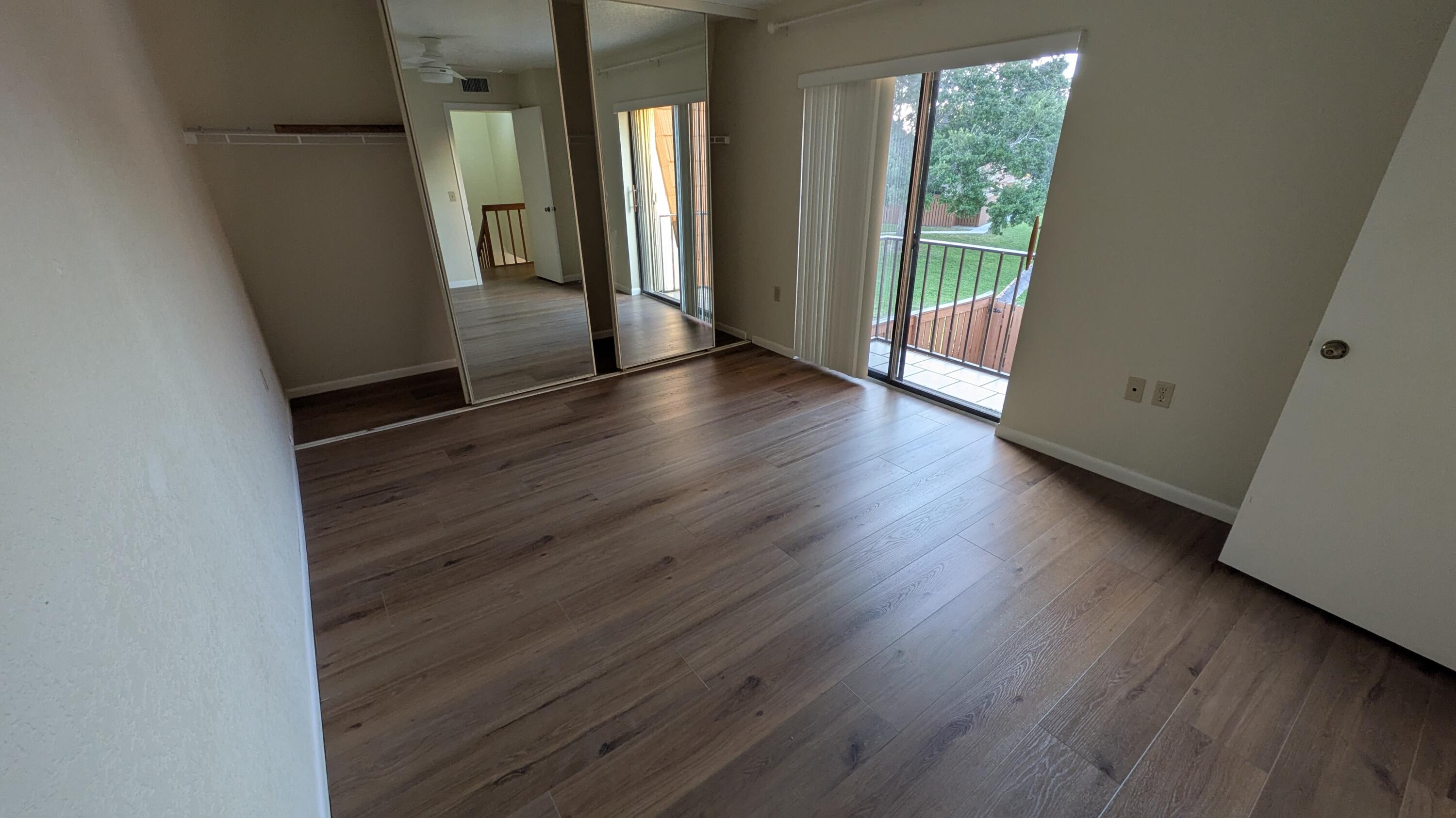 3900 County Line Road, Unit 21D Tequesta, FL 33469 - Photo 16 of 20 an empty room with wooden floor and windows