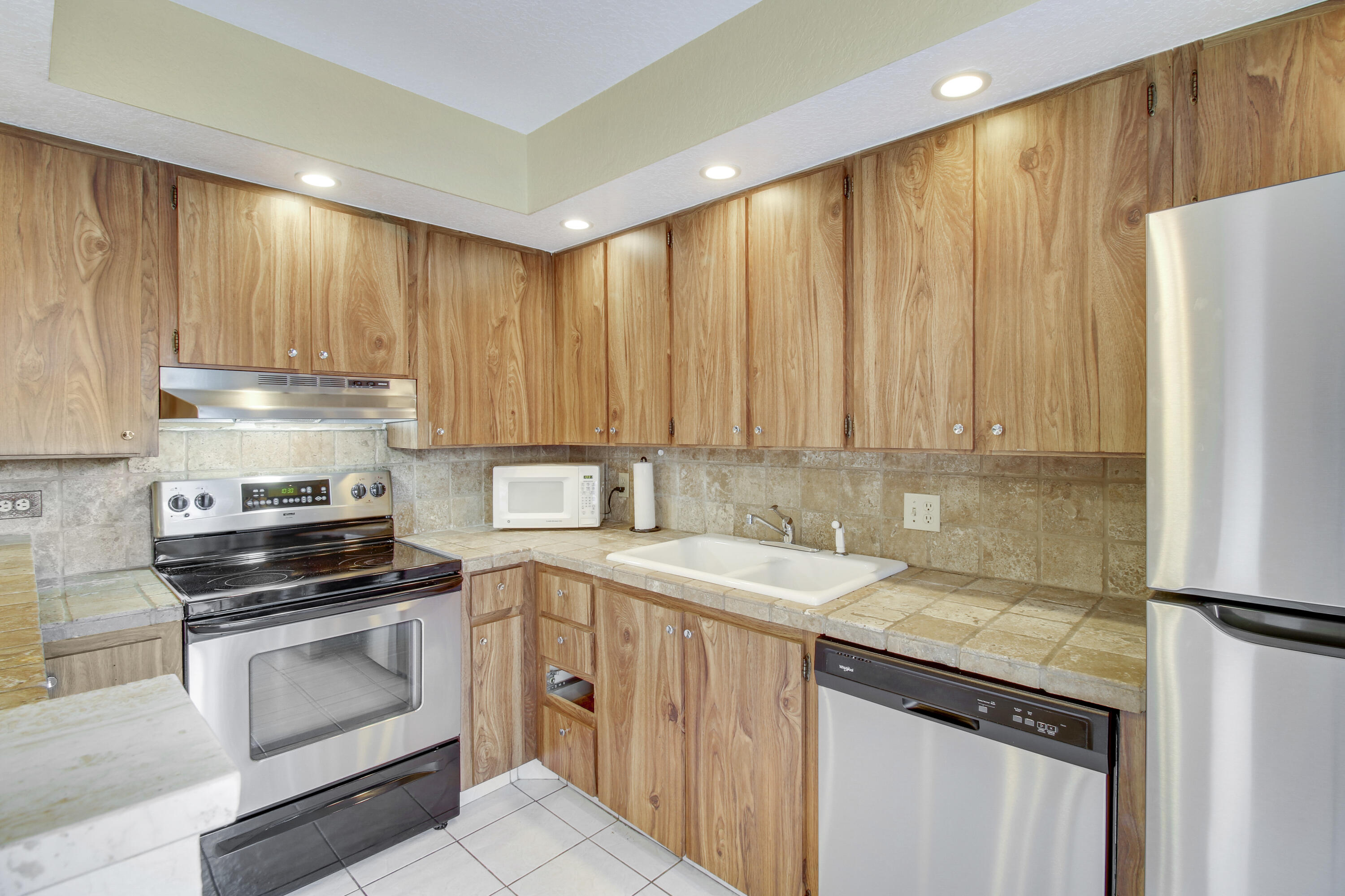3900 County Line Road, Unit 21D Tequesta, FL 33469 - Photo 9 of 20 a kitchen with a sink and a refrigerator