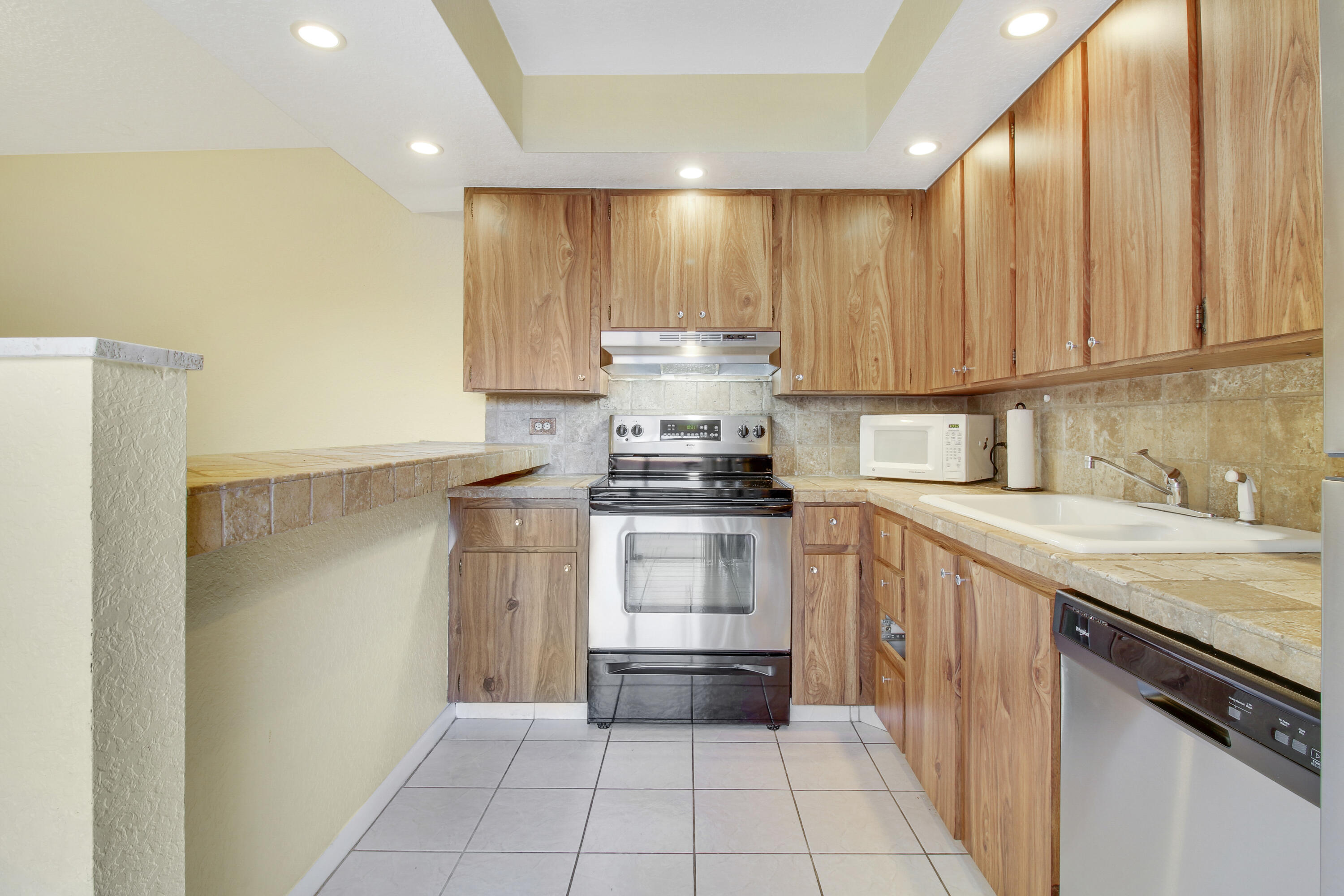 3900 County Line Road, Unit 21D Tequesta, FL 33469 - Photo 10 of 20 a kitchen with a stove top oven and cabinets