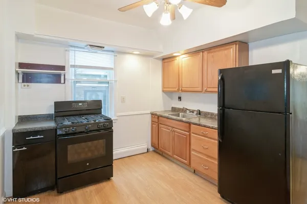 a kitchen with granite countertop a refrigerator stove and sink