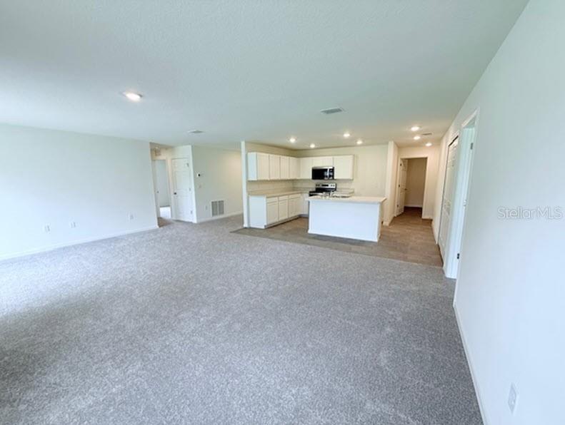 39 Slipper Trail Palm Coast, FL 32164 - Photo 3 of 13 an empty room with kitchen and windows