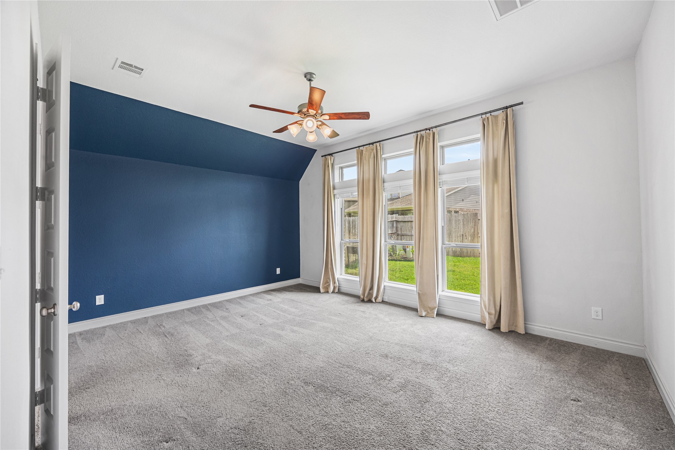28169 Knight Peak Drive Spring, TX 77386 - Photo 14 of 33 a view of an empty room with a fireplace and a ceiling fan