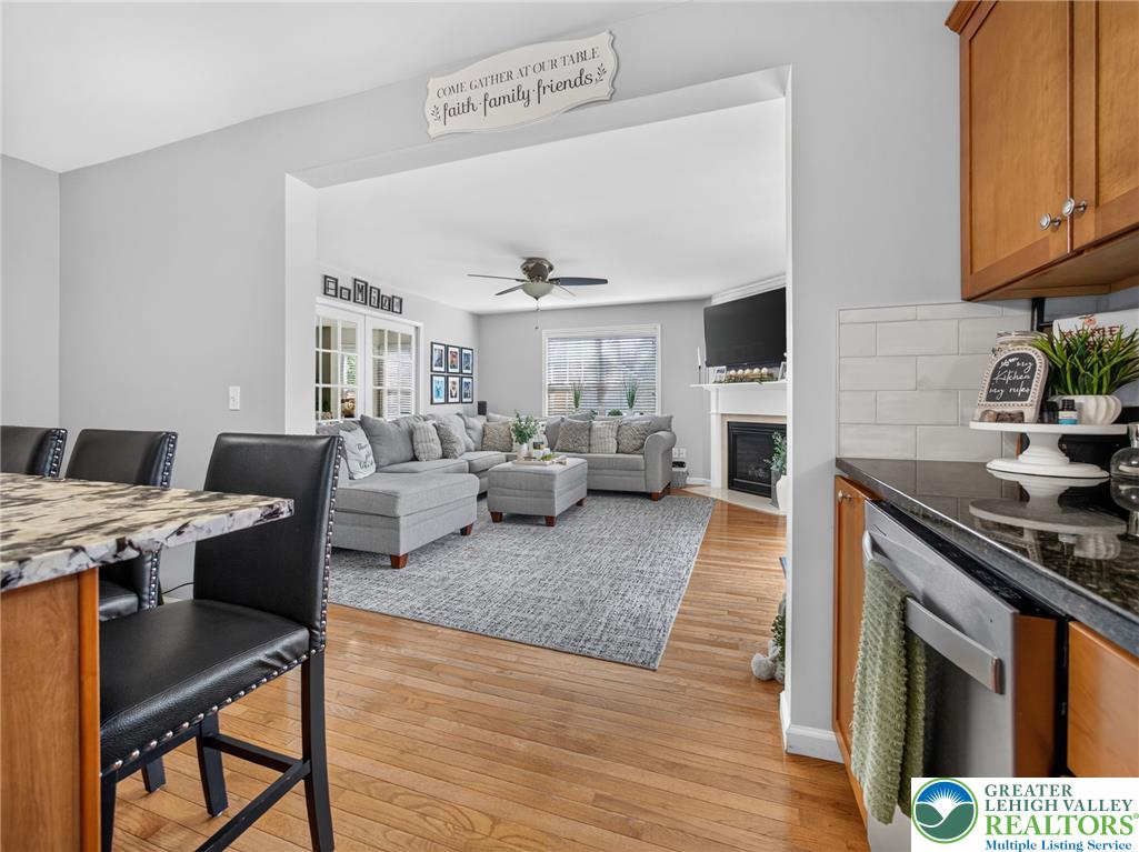 4148 Ross Road Bethlehem, PA 18020 - Photo 30 of 67 An open concept living area boasts hardwood floors, a cozy fireplace, and an elegant ceiling fan.
